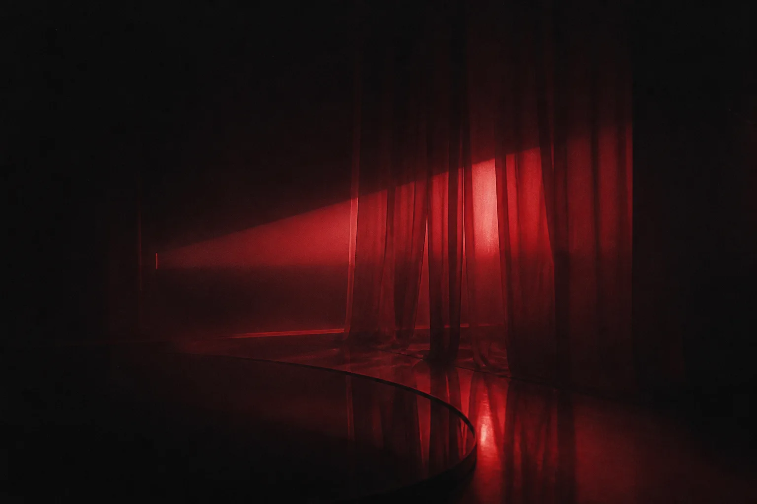 Abstract red light falling across dark curtains
